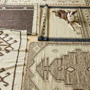 The floor is covered in natural colour jute rugs in a variety of patterns. A dog sits upon one in the top right corner.