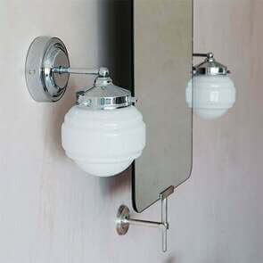 Two chrome round bathroom wall lights hang either side of a silver swivel bathroom mirror.