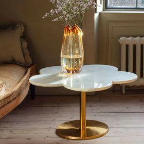 A daisy shaped marble coffee table with a gold circular base has a peach colour vase with a bunch of small pink flowers.